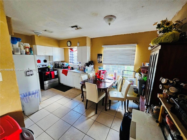 dining space featuring light tile patterned flooring, visible vents, and a healthy amount of sunlight