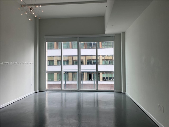 253 NE 2nd St Unit 324, Miami, FL 33132 - spare room with concrete flooring, baseboards, and a chandelier