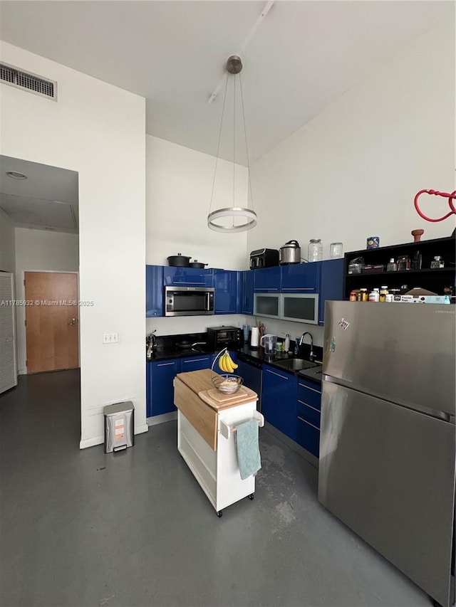 253 NE 2nd St Unit 324, Miami, FL 33132 - kitchen featuring stainless steel appliances, blue cabinets, dark countertops, concrete floors, and a sink