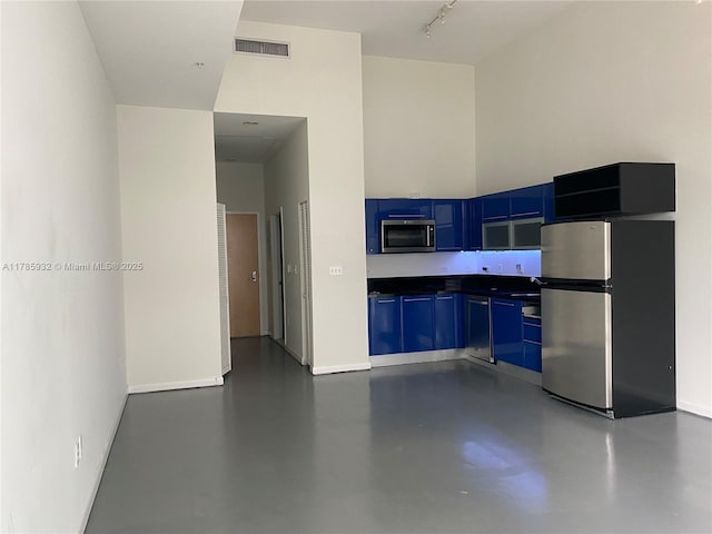 253 NE 2nd St Unit 324, Miami, FL 33132 - kitchen featuring appliances with stainless steel finishes, blue cabinets, concrete flooring, dark countertops, and baseboards