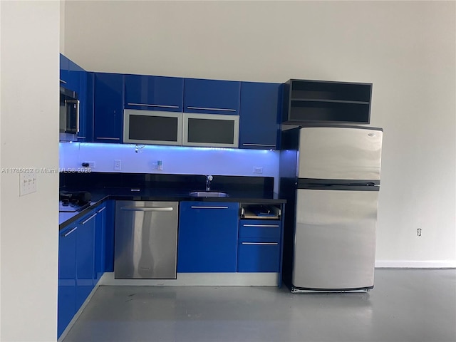 253 NE 2nd St Unit 324, Miami, FL 33132 - kitchen with appliances with stainless steel finishes, a sink, dark countertops, concrete floors, and blue cabinets