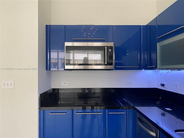 253 NE 2nd St Unit 324, Miami, FL 33132 - kitchen featuring appliances with stainless steel finishes, blue cabinetry, and dark countertops