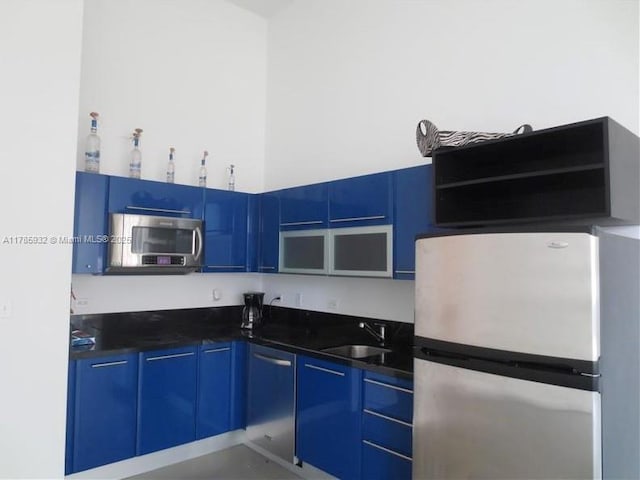253 NE 2nd St Unit 324, Miami, FL 33132 - kitchen featuring appliances with stainless steel finishes, a sink, blue cabinets, and dark countertops