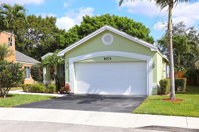9271 Arborwood Cir, Davie, FL 33328 - ranch-style home with stucco siding, driveway, a garage, and a front yard