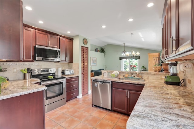 9271 Arborwood Cir, Davie, FL 33328 - kitchen featuring stainless steel appliances, vaulted ceiling, a peninsula, backsplash, and recessed lighting
