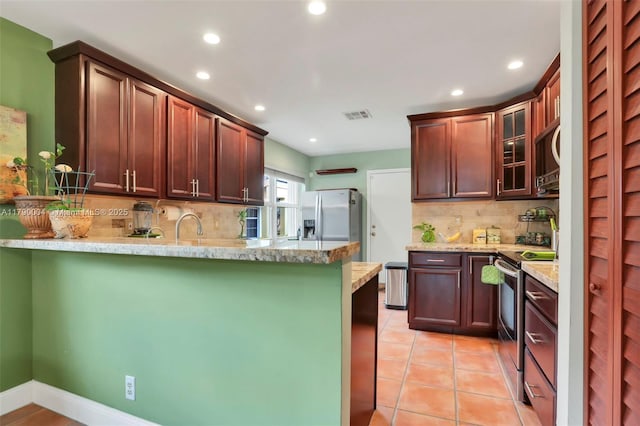 9271 Arborwood Cir, Davie, FL 33328 - kitchen featuring appliances with stainless steel finishes, a peninsula, recessed lighting, tasteful backsplash, and glass insert cabinets