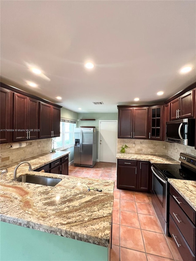 9271 Arborwood Cir, Davie, FL 33328 - kitchen featuring appliances with stainless steel finishes, light tile patterned floors, decorative backsplash, light stone counters, and recessed lighting