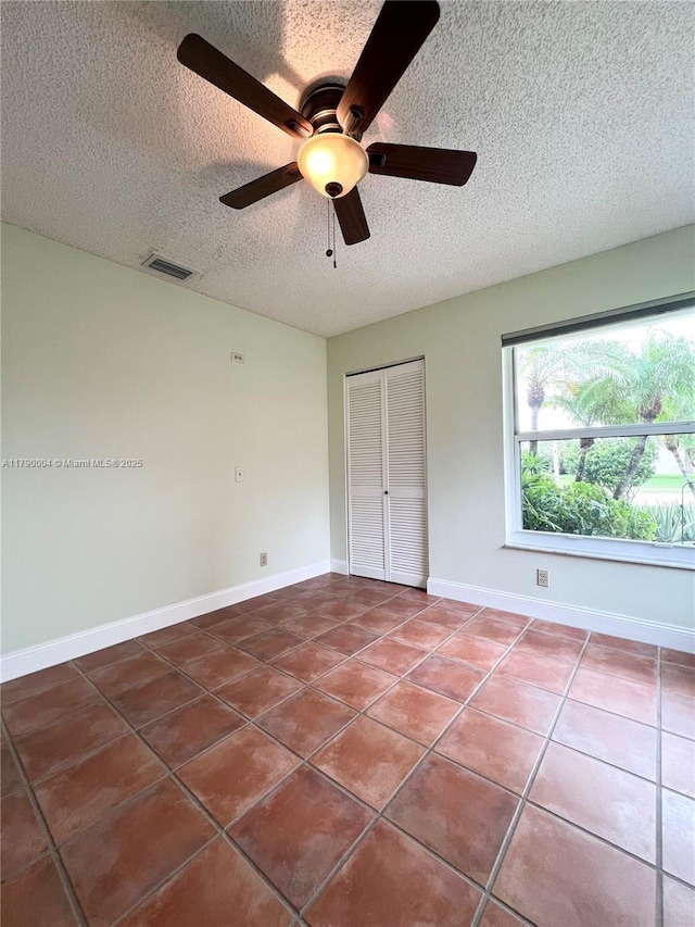 9271 Arborwood Cir, Davie, FL 33328 - unfurnished bedroom featuring a textured ceiling, tile patterned floors, a closet, and a ceiling fan