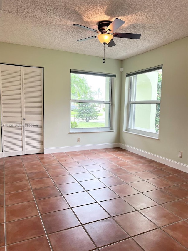 9271 Arborwood Cir, Davie, FL 33328 - unfurnished bedroom with a textured ceiling, tile patterned flooring, a closet, and ceiling fan