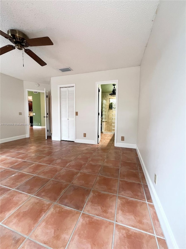9271 Arborwood Cir, Davie, FL 33328 - unfurnished bedroom with tile patterned flooring, a textured ceiling, a closet, ceiling fan, and ensuite bathroom