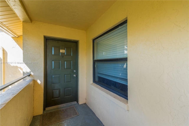view of exterior entry featuring stucco siding