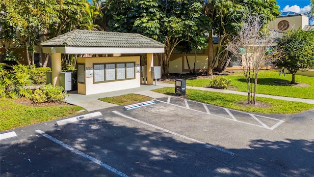 surrounding community with uncovered parking, a yard, and mail area