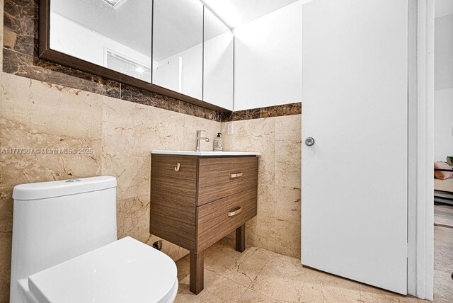 10185 Collins Ave Unit 1003, Bal Harbour, FL 33154 - bathroom with tile walls, toilet, and vanity