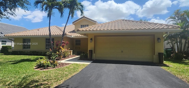 mediterranean / spanish-style house featuring a tile roof, a garage, aphalt driveway, a front lawn, and stucco siding