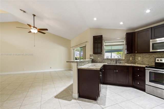 kitchen featuring a sink, appliances with stainless steel finishes, tasteful backsplash, and lofted ceiling