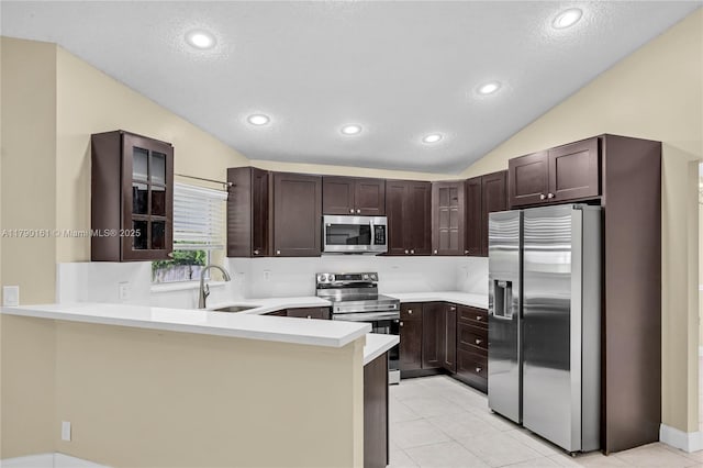 3562 W Southern Orchard Rd W, Davie, FL 33328 - kitchen with appliances with stainless steel finishes, a peninsula, vaulted ceiling, dark brown cabinetry, and light countertops