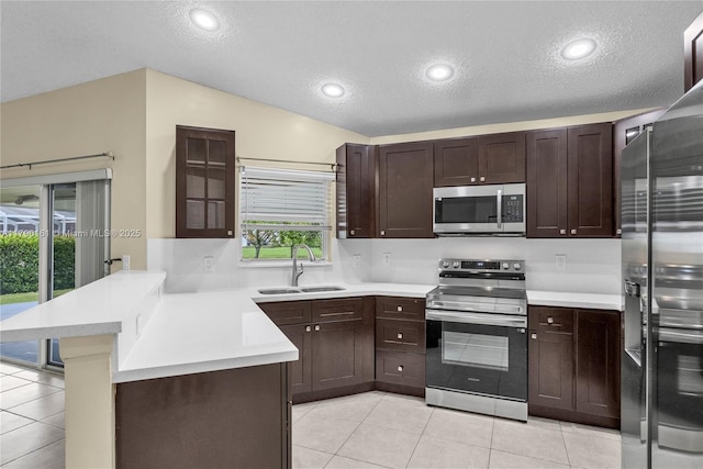 3562 W Southern Orchard Rd W, Davie, FL 33328 - kitchen with appliances with stainless steel finishes, a peninsula, a textured ceiling, light tile patterned flooring, and light countertops