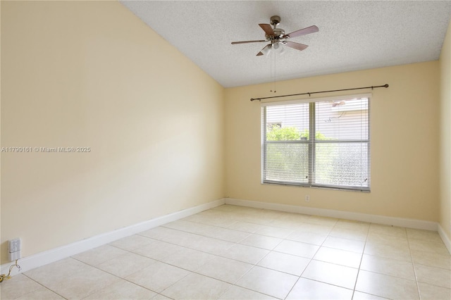 empty room with a ceiling fan, a textured ceiling, light tile patterned floors, baseboards, and lofted ceiling