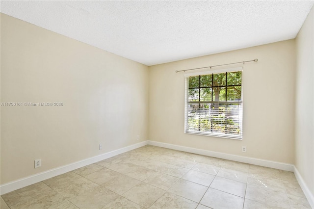 unfurnished room with baseboards, a textured ceiling, and light tile patterned floors