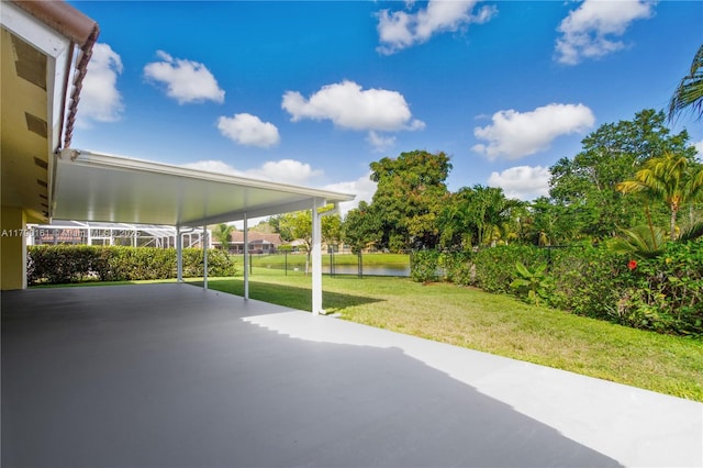 view of patio with a water view and fence