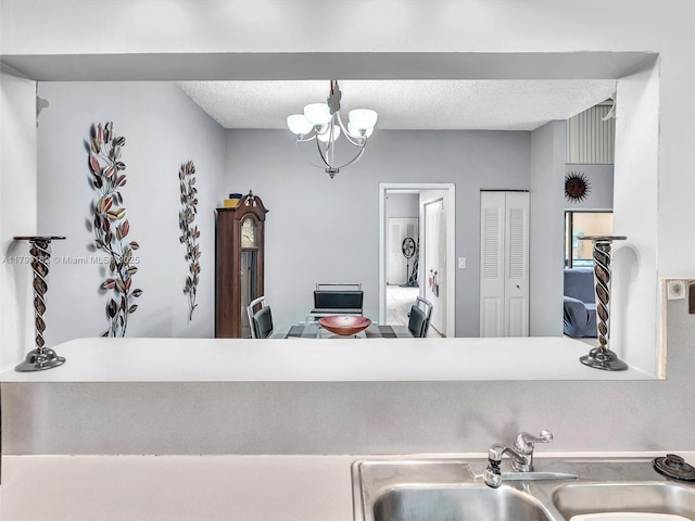 9401 NW 14th Ct Unit 224, Pembroke Pines, FL 33024 - kitchen with a textured ceiling, a sink, and a chandelier