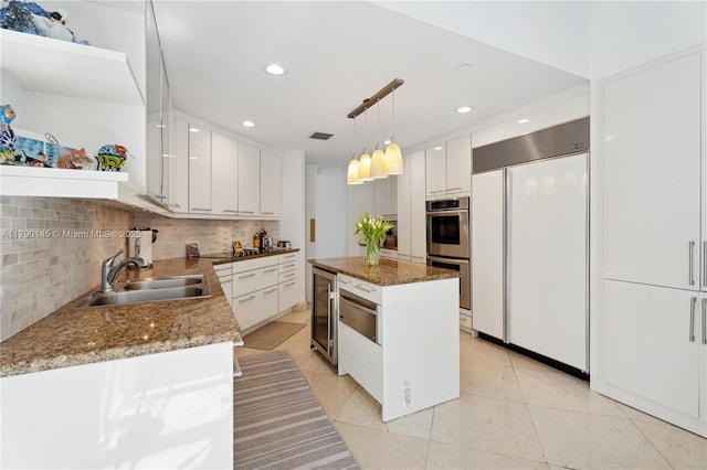 10225 Collins Ave Unit 904, Bal Harbour, FL 33154 - kitchen featuring paneled built in refrigerator, beverage cooler, backsplash, white cabinets, and a center island