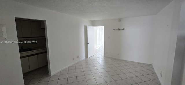2420 Diana Dr Unit 203, Hallandale Beach, FL 33009 - spare room featuring a textured ceiling, light tile patterned floors, and baseboards