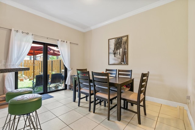 dining area with light tile patterned floors, crown molding, and baseboards
