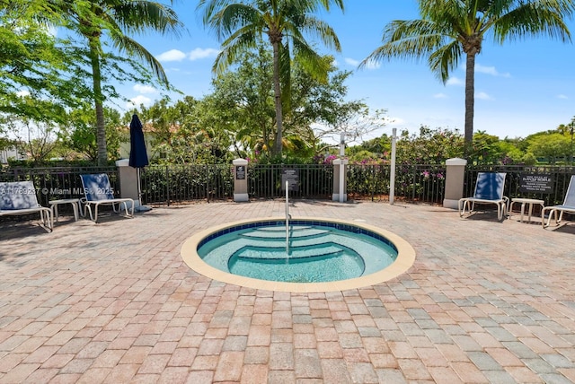 view of pool with a community hot tub, fence, and a patio area