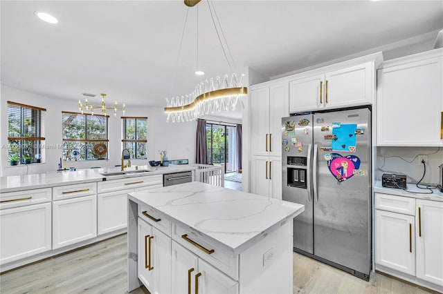 kitchen with recessed lighting, a center island, appliances with stainless steel finishes, and a sink