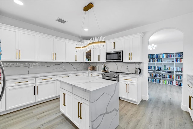 kitchen featuring white cabinetry, stainless steel appliances, and backsplash