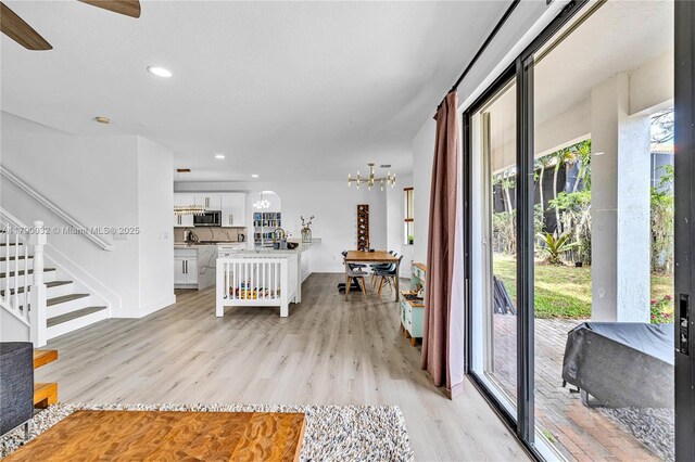 entrance foyer featuring baseboards, recessed lighting, stairway, and light wood-style floors