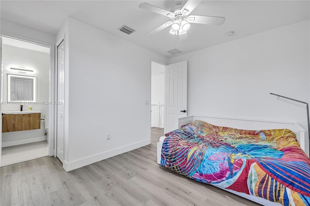 bedroom featuring a ceiling fan, visible vents, wood finished floors, and ensuite bath