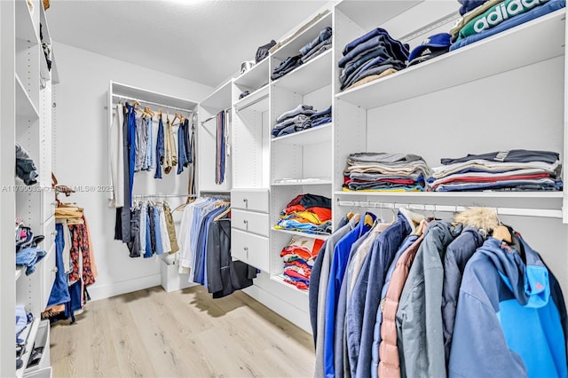 walk in closet with wood finished floors