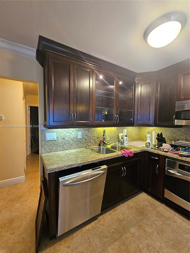 kitchen featuring a sink, dark brown cabinetry, decorative backsplash, crown molding, and appliances with stainless steel finishes