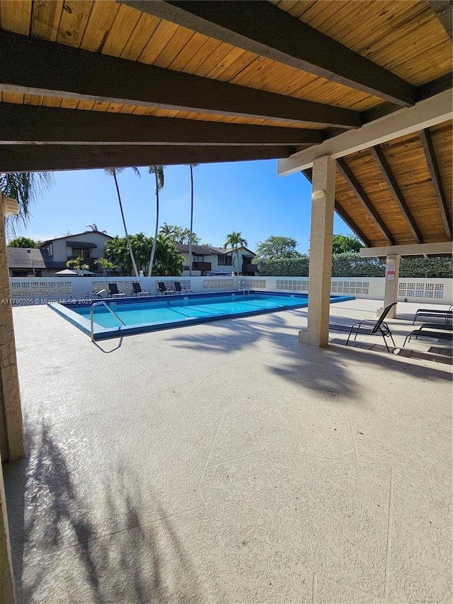 community pool featuring a patio and fence