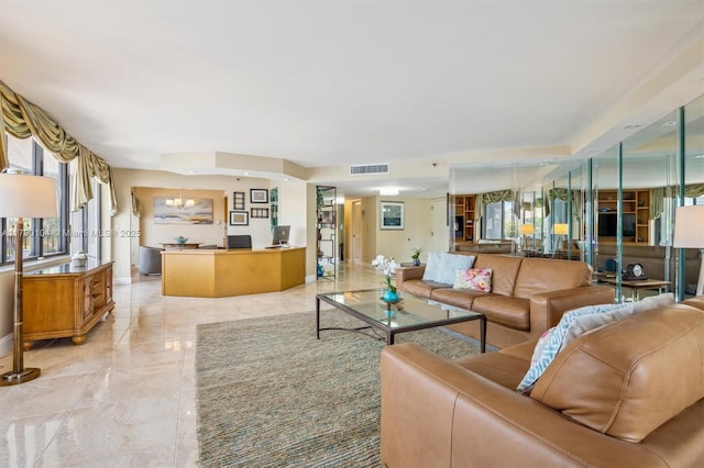 living area with visible vents, baseboards, and a notable chandelier