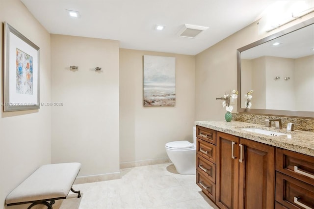 bathroom with baseboards, vanity, and toilet