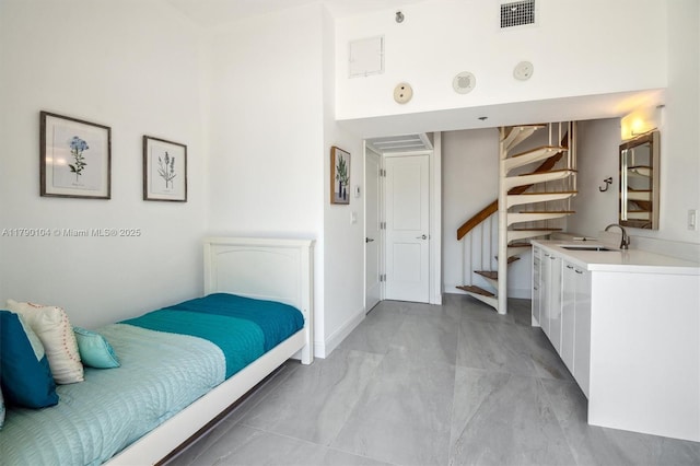 bedroom with a towering ceiling, a sink, and visible vents