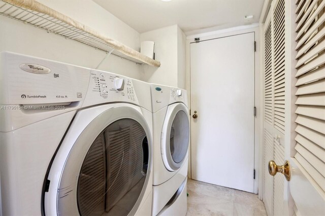 clothes washing area with washing machine and clothes dryer and laundry area