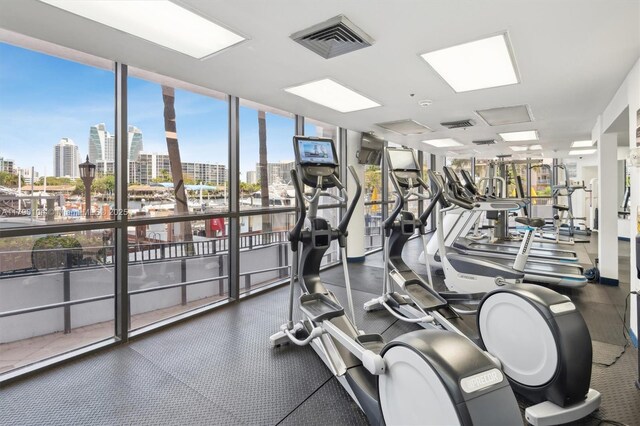 gym with a wall of windows, visible vents, and a view of city