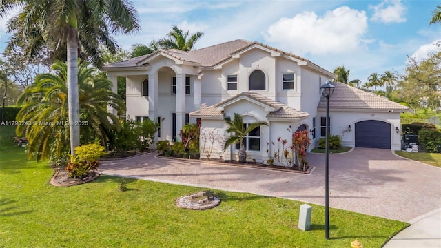 15355 SW 34th St, Davie, FL 33331 - mediterranean / spanish-style home with decorative driveway, stucco siding, a garage, a tile roof, and a front yard