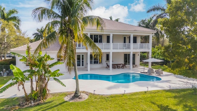15355 SW 34th St, Davie, FL 33331 - rear view of property with a balcony, a tile roof, a patio area, stucco siding, and an outdoor pool