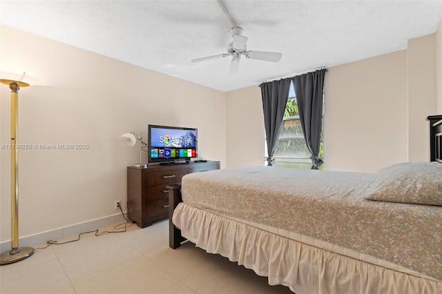 bedroom featuring light tile patterned floors, a ceiling fan, a textured ceiling, and baseboards