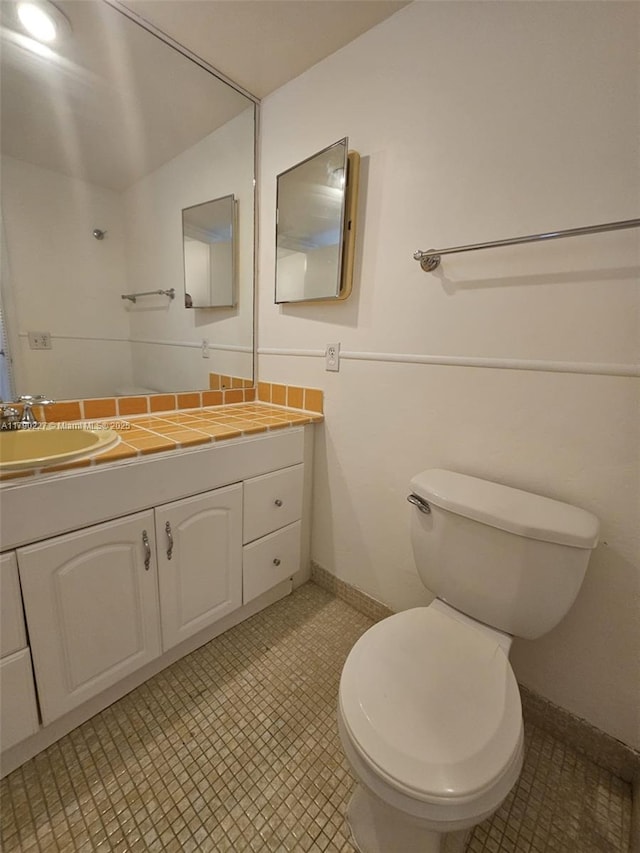 bathroom featuring vanity, toilet, and baseboards
