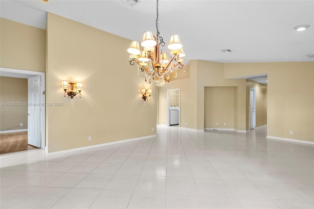 empty room featuring light tile patterned floors, baseboards, visible vents, a notable chandelier, and a high ceiling
