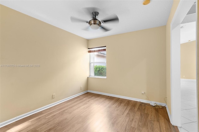 unfurnished room with baseboards, wood finished floors, and a ceiling fan