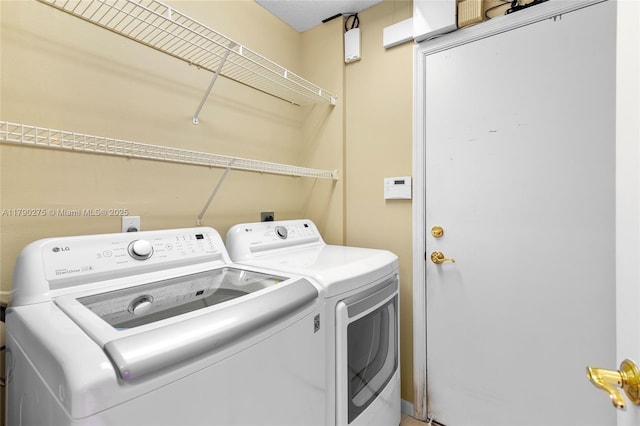 washroom with independent washer and dryer and laundry area