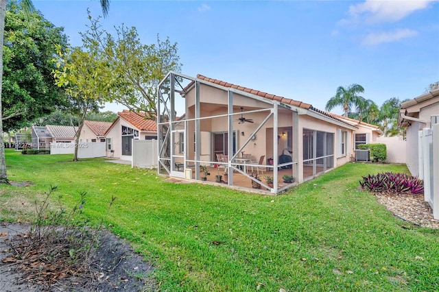 rear view of property featuring a yard, stucco siding, a tiled roof, and a patio area
