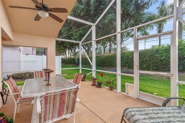 sunroom / solarium featuring a ceiling fan and outdoor dining space